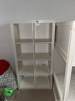 Front view of one white IKEA Kallax shelving unit showing 8 square compartments.