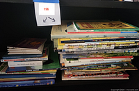 Large stack of assorted children's books with colorful covers and visible titles