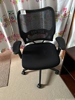 Front view of black mesh office chair showing mesh back, padded seat and armrests.