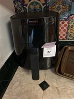 Front view of the black Philips air fryer with a handle for the basket.