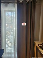 Curtains hung with sheers behind on window, showing height and draping.