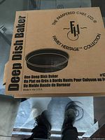 Closed box of the deep dish baker showing the Pampered Chef Family Heritage Collection branding and product name.