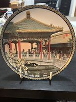 Front of decorative porcelain plate showing Pavilion of Floating Jade-Green with intricate painted details and decorative border.