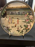 Front view of the decorative plate showing the Nine Dragon Wall scene with figures and floral border