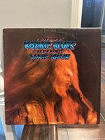 Front cover of Janis Joplin's Kosmic Blues album, showing the singer performing with microphone and album title text.