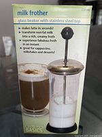 Photo of Kitchen Basics milk frother box and product, showing product description and frother in use with milk froth and latte.