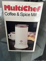 Photo of Multichef Coffee and Spice Mill in original packaging showing the product with white body and transparent lid.