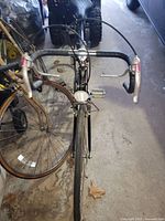 Front view of black SureFlight bicycle showing drop handlebars, brake levers, and front wheel.