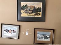 Three watercolour paintings on wall showing rural buildings and landscape scenes.