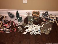 Overview of four buildings and assorted accessories on hardwood floor