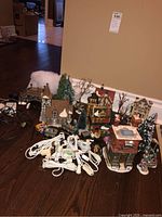 Overview showing four ceramic buildings, trees, figurines and light cords