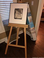 Wooden easel standing with original packaging visible behind it.