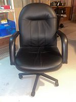 Front view of black vinyl office chair showing padded seat, backrest and armrests.