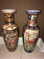 Two tall Royal Satsuma vases side by side showing overall colors and height.