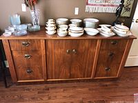 Full front view of sideboard cabinet with items on top illustrating size and finish.