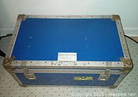 Top view of blue Paramount Pictures flight case showing metal edging, rivets, and label