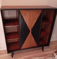 Front view of curved front bookcase showing center geometric veneer door and side shelves