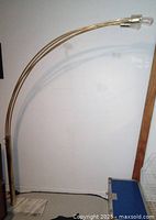 Full view of the brass-colored arc floor lamp showing the four curved arms and bulb sockets extending from the base up to around 80 inches tall and wide.