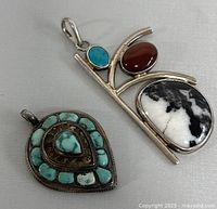 Two vintage 925 silver pendants featuring turquoise and other stones on a white background.