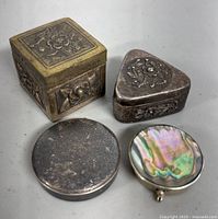 Top view showing all five vintage metal pill boxes with varied shapes and designs.