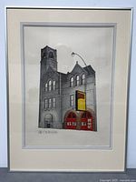 Front view of framed lithograph showing building with red doors and artist's signature.