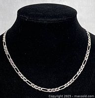 Classic Figaro chain necklace draped on black bust showing front view and chain detail.