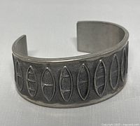 Pewter cuff bracelet front view showing the elongated oval pattern.