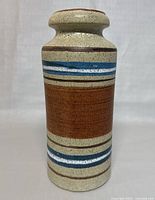 Front view of the 12-inch tall cylindrical pottery vase showing speckled beige base with horizontal bands.