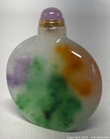 Image showing front side of the small jade perfume/snuff bottle with multi-color pattern and purple stopper.