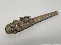 Side angled view of silver plated dragon head pipe showing detailed dragon face and tapered pipe body.