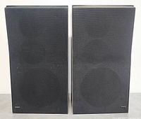 Front view of two vintage Beovox S35 speakers with black cloth grills attached.