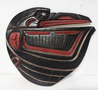 Front of the Haida eagle carved wood wall plaque showing red, black and natural wood colors in traditional indigenous art style.