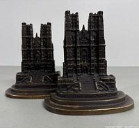 Front and side view of the pair of vintage solid metal Brussels Cathedral bookends on a white background, showing the detailed architectural features and stepped base with inscription.