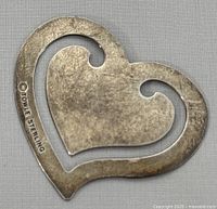 Photo showing front view of heart-shaped sterling silver bookmark with visible texture and shape.