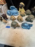 Full view of all 12 figurines showing variety of turtles, elephants, and two dog figurines arranged on table
