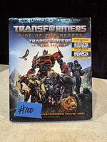 Front cover image of the sealed 4K Ultra HD Blu-ray and DVD steelbook for Transformers: Rise of the Beasts showing movie artwork and bonus content information.