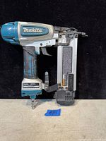 Full side view of Makita AF506 air nail tool showing design and wear