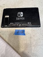 Rear view of Nintendo Switch console with Nintendo branding, visible wear and scratches.