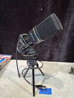 Front angled view of the Scorpion condenser microphone on the black tripod stand, cable coiled around the stand.