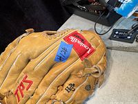 Top and back view showing TPS red logo and Louisville Slugger patch in leather glove.