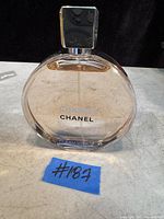 Photo of clear 5 oz Chanel Chance Eau Vive perfume bottle with black square top and Chanel branding on glass.