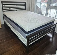 Full view of assembled metal frame, mattress, and box spring