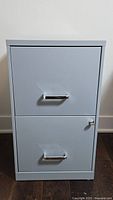 Front view of the two-drawer metal filing cabinet with locked drawers and handles.