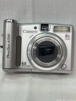 Front view of Canon PowerShot A700 digital camera showing lens details, flash, and branding.