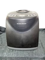 Front view of black Hamilton Beach bread maker showing brand name and overall body condition.