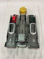 Top view of yellow truck and two sports cars on grey plastic vehicle carrier.