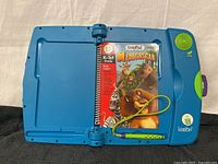 Open LeapPad device showing Madagascar K-1st grade book and attached stylus.