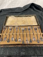 Set of 12 vintage pastry forks displayed in original cardboard case