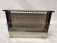 Front view photo showing the stainless steel front panel with the Montline brand logo and the metal wire rack/guard for bread.