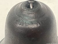 Close-up of the bell's top showing the cast iron material and clapper mounting structure.